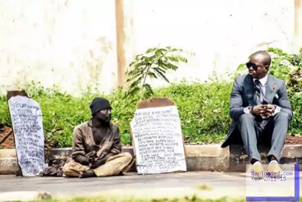 Uche Nnaji shares a photo of himself sitting next to a homeless man